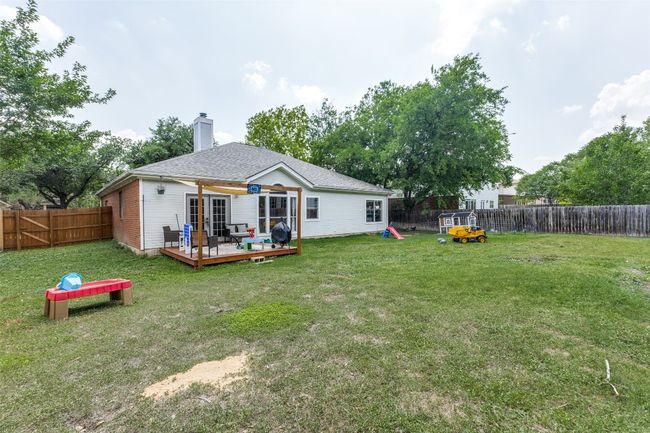 Back of property featuring a deck, a chimney, and french doors | Image 23