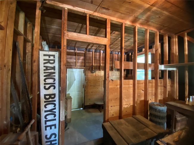 Misc room with concrete flooring, vaulted ceiling, and wood walls | Image 17