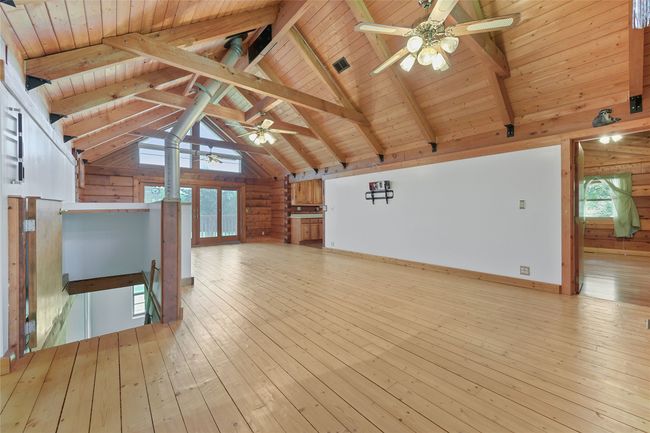 Without Virtual Staging. With view of stairs to lower level with walkout, Exterior windows with electric shades, Kitchen, and entrance to Primary Bedroom. | Image 11