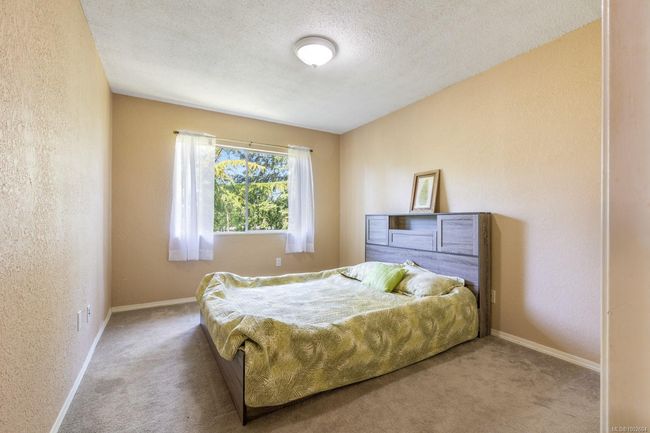 Carpeted bedroom featuring a textured wall, a textured ceiling, and baseboards | Image 15