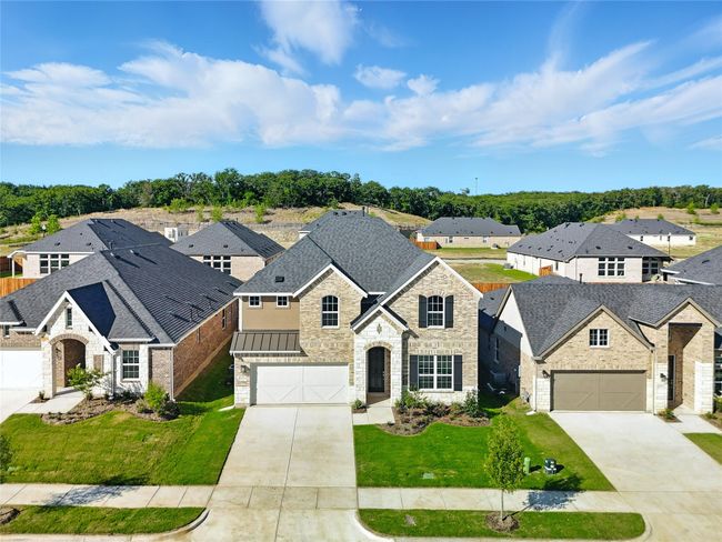 French country style house featuring driveway, stone siding, a residential view, and a front yard | Image 36