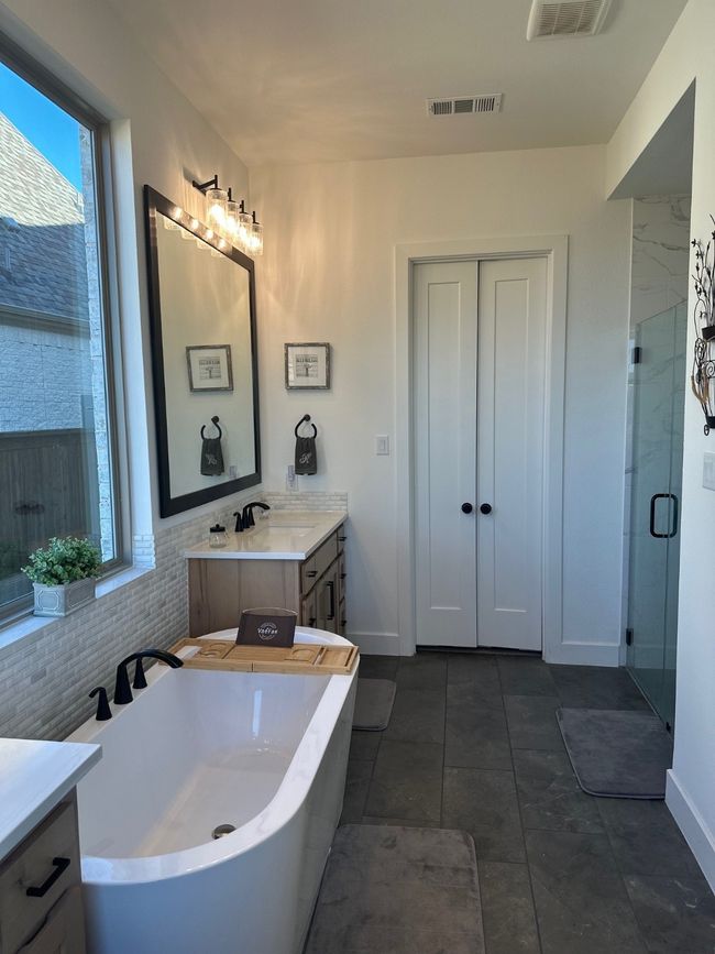 Bathroom with a soaking tub, visible vents, vanity, and a shower stall | Image 24