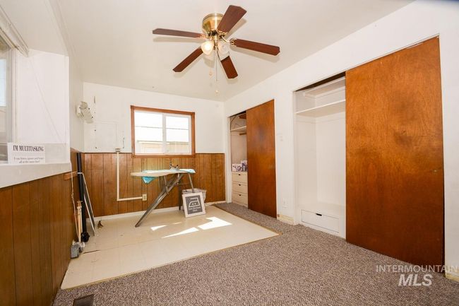 Empty room featuring wainscoting, ceiling fan, carpet flooring, and wood walls | Image 28