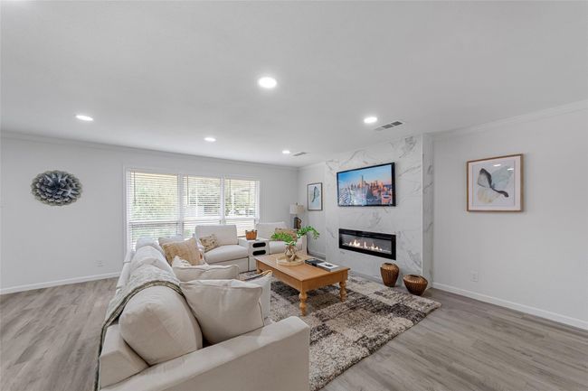 Living area featuring ornamental molding, light wood-style floors, a high end fireplace, and recessed lighting | Image 4