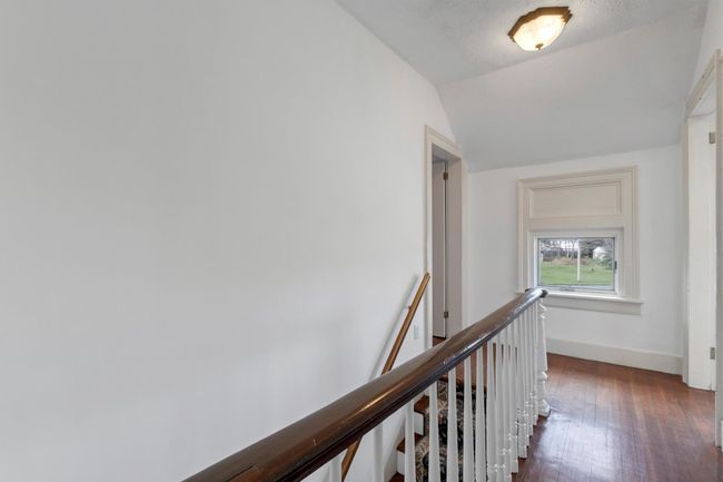 Hallway featuring an upstairs landing, dark wood-style flooring, vaulted ceiling, and baseboards | Image 36