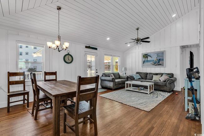 Dining space featuring vaulted ceiling, ceiling fan with notable chandelier, hardwood / wood-style floors, and wooden ceiling | Image 5