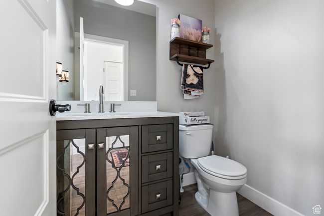 Half bath featuring baseboards, wood finished floors, toilet, and vanity | Image 18