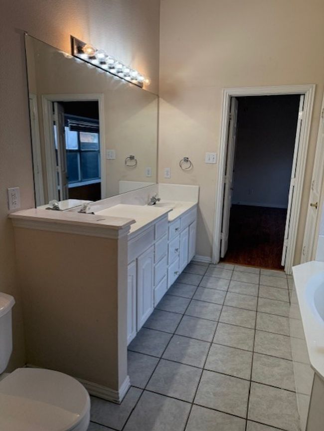Full bathroom featuring tile patterned flooring, double vanity, and a tub | Image 13
