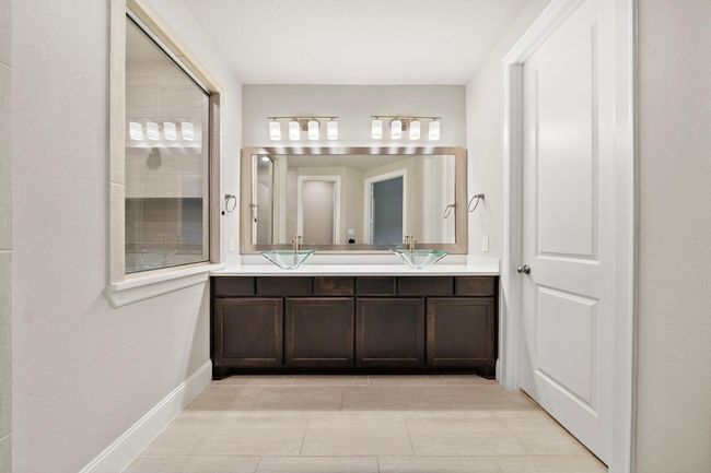 Another view of the vanity area featuring a framed mirro. | Image 12