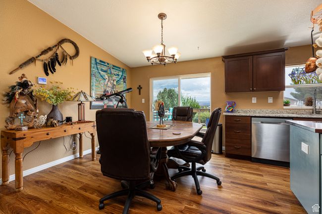 Dining space featuring lofted ceiling, hardwood / wood-style floors, and a chandelier | Image 11