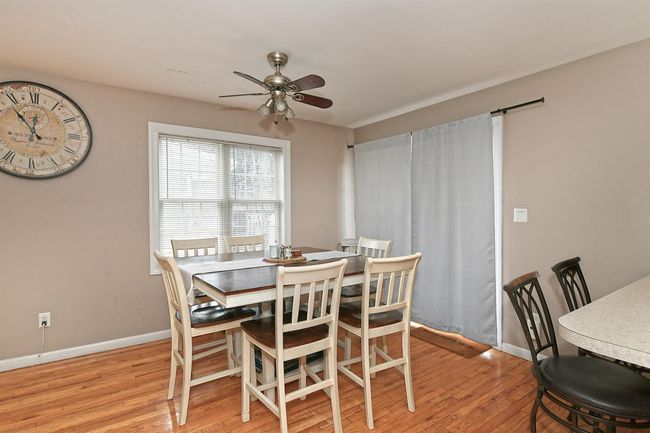Dining space with baseboards, light wood-type flooring, and ceiling fan | Image 14