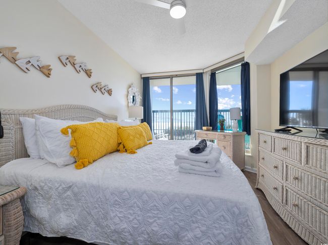 Bedroom with expansive windows, a textured ceiling, access to exterior, and dark wood-style flooring | Image 23