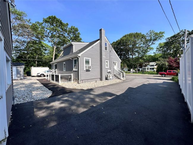 View of side of property featuring a chimney, cooling unit, and entry steps | Image 8