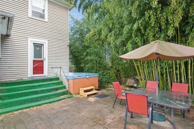 View of patio with outdoor dining area and a hot tub | Image 26