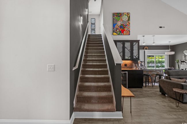 Staircase with wood finished floors, wine cooler, and high vaulted ceiling | Image 24
