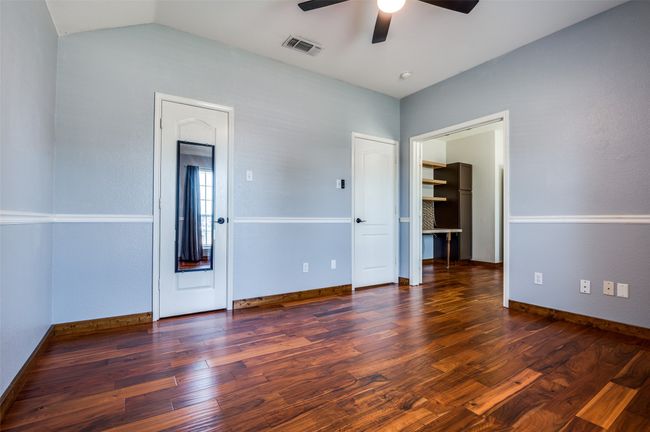 Empty room featuring a ceiling fan, wood finished floors, and lofted ceiling | Image 5