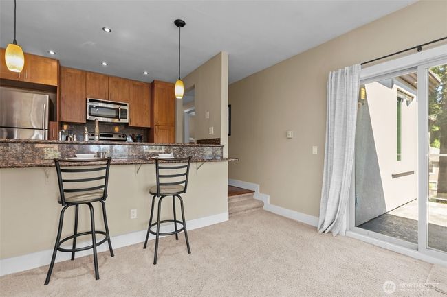 In addition to the windows, there is a sliding glass door to an east-facing balcony. Just 2 stairs into this portion of the main living area. | Image 10