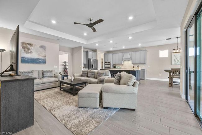 Living area featuring recessed lighting, baseboards, a raised ceiling, and a ceiling fan | Image 26