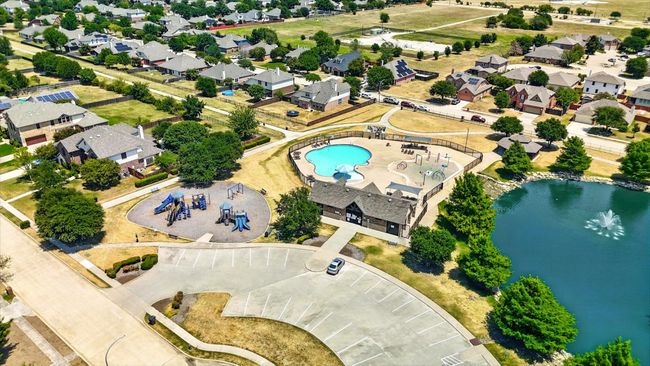 Aerial perspective of suburban area with a pool and a nearby body of water | Image 21