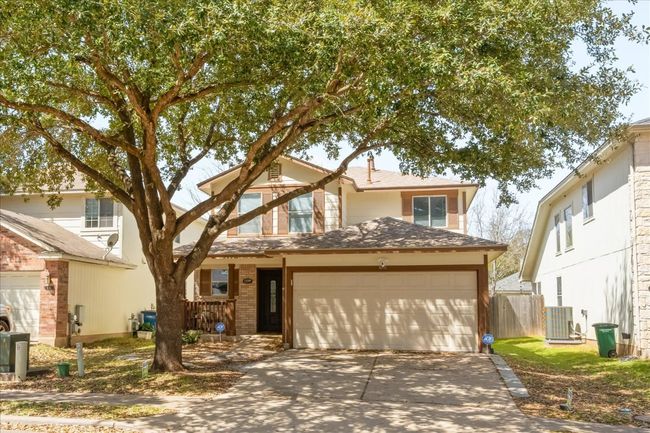 Traditional-style home featuring fence, roof with shingles, concrete driveway, brick siding, and central AC unit | Image 5