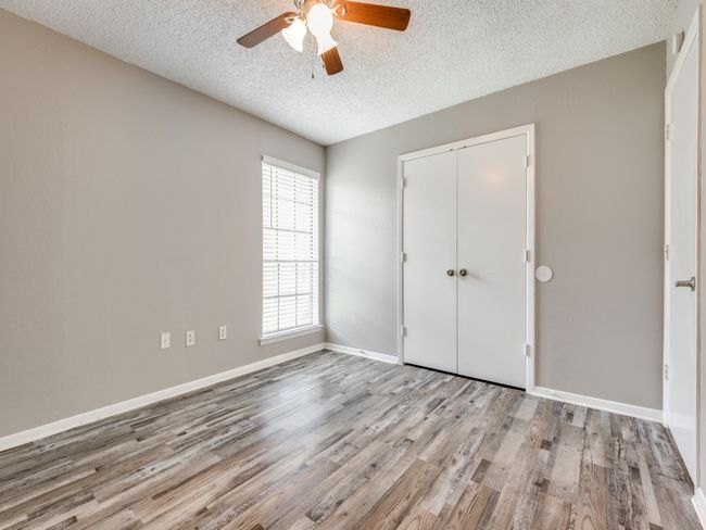 Unfurnished bedroom featuring wood finished floors, a textured ceiling, a closet, and a ceiling fan | Image 11