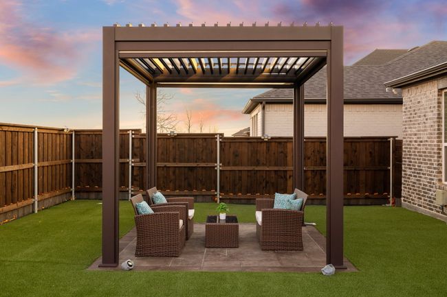 Patio terrace at dusk with an outdoor living space, a pergola, and a lawn | Image 26