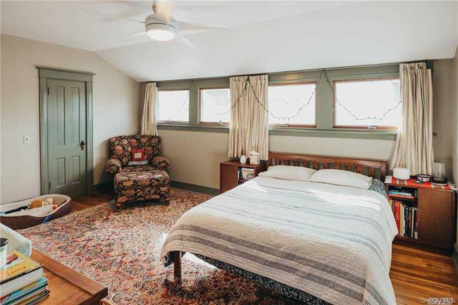 Bedroom featuring lofted ceiling, wood finished floors, and ceiling fan | Image 39