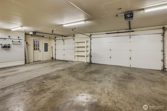 Clean as a whistle. Big, bright garage boasts space for 3 cars, a work bench and its own side entrance area. | Image 31