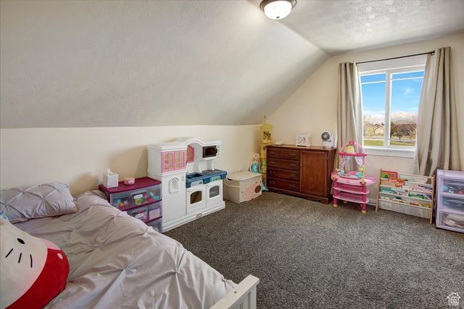 Bedroom with a textured ceiling, vaulted ceiling, and carpet floors | Image 19