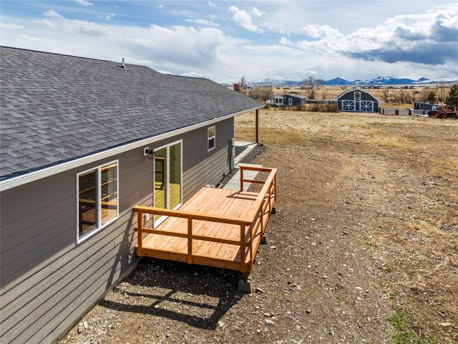 Wooden terrace featuring an outdoor structure, a storage unit, and a mountain view | Image 4
