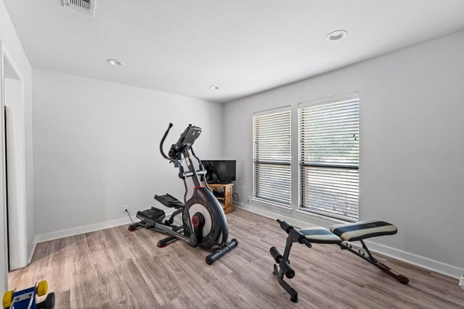Currently set as an exercise area with baseboards, wood finished floors. | Image 13