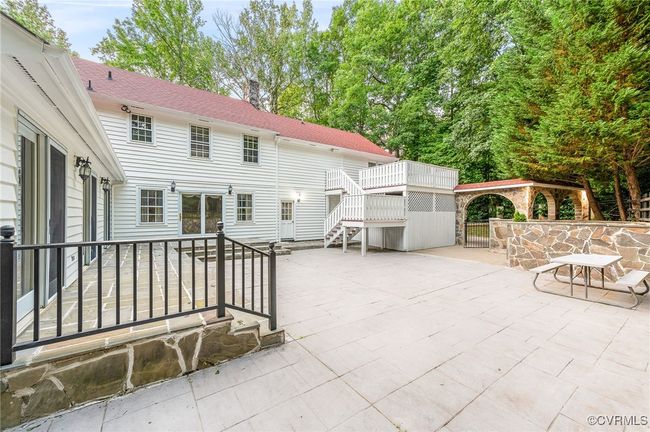 From the Florida and living rooms, step onto this split-level patio—where a stone arch invites you to the pool, and the elevated tier hosts your private basketball court. | Image 38