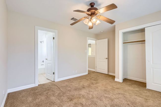 Unfurnished bedroom with a closet, baseboards, light carpet, ensuite bath, and visible vents | Image 31