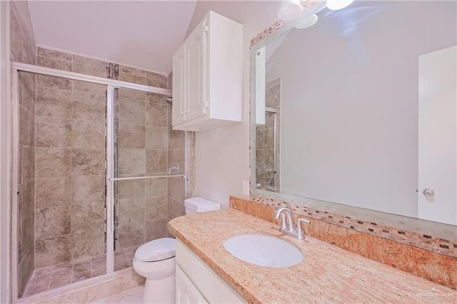 Bathroom with vanity, toilet, and a stall shower | Image 23