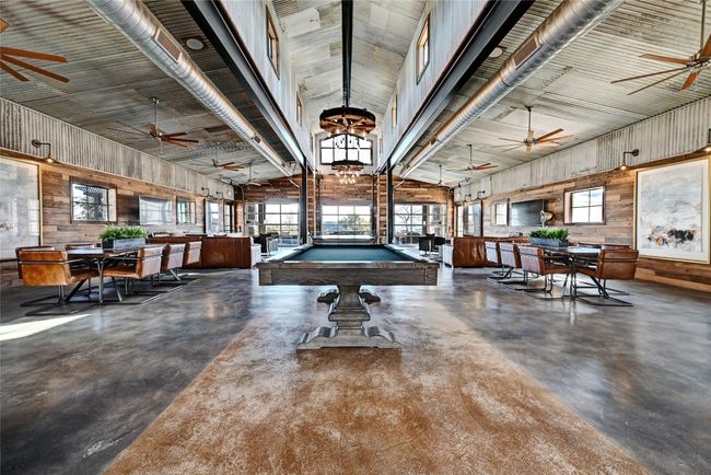 Game room with finished concrete flooring, ceiling fan, billiards, and vaulted ceiling | Image 39