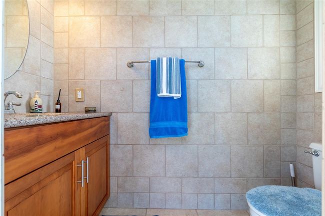 Half bath next to shower with wood cabinet | Image 22