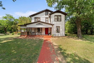 View of front of home with covered porch and a front yard | Image 1