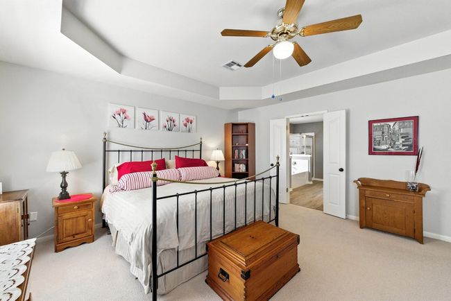 Carpeted bedroom featuring a tray ceiling and ceiling fan | Image 17