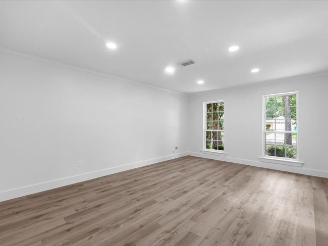 This room features spacious, open living with light wood floors, fresh white walls, and large windows providing ample natural light. Ideal for creating a bright and welcoming space. | Image 19