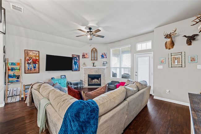 Living area featuring dark wood finished floors, ceiling fan, and baseboards | Image 16
