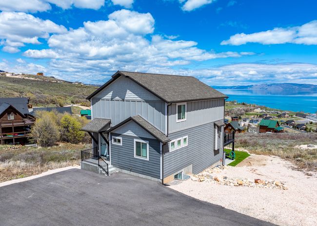 View of property exterior with a water view, driveway, and a shingled roof | Image 46