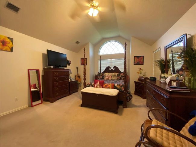 Carpeted bedroom with ceiling fan and lofted ceiling | Image 25