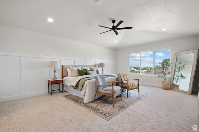 Carpeted Primary bedroom featuring a decorative wall, recessed lighting, a vaulted ceiling with ceiling fan, and wainscoting | Image 19