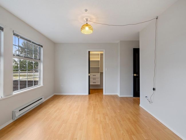 Unfurnished room with baseboards, baseboard heating, and light wood-type flooring | Image 11