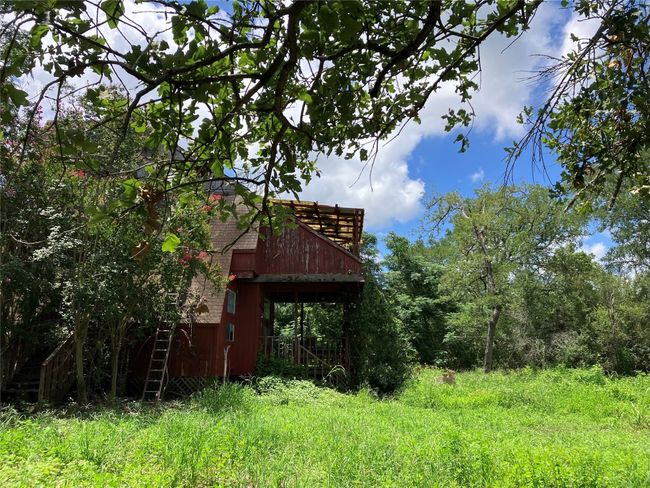 A-Frame House in need of repair or removal. Property is secluded with mature native trees. | Image 12