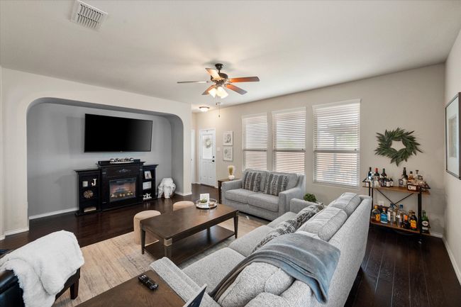 Living room with visible vents, baseboards, wood finished floors, and ceiling fan | Image 20