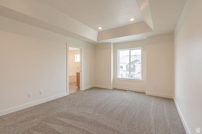 Spare room featuring a raised ceiling, plenty of natural light, light carpet, recessed lighting, and a textured ceiling | Image 18