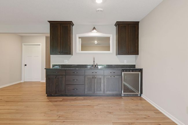 Lower level is complete with custom wet bar, cabinets and bar refrigerator | Image 38
