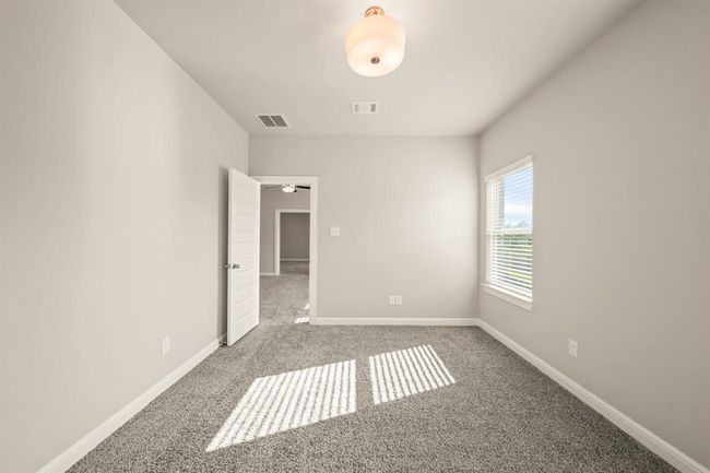 Secondary bedroom filled with natural light and soft carpeted flooring. | Image 27