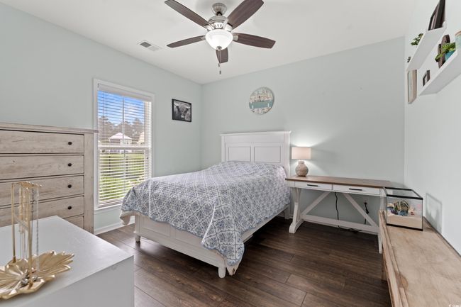 Bedroom on the first level with dark wood-style floors and a walk in closet. | Image 9